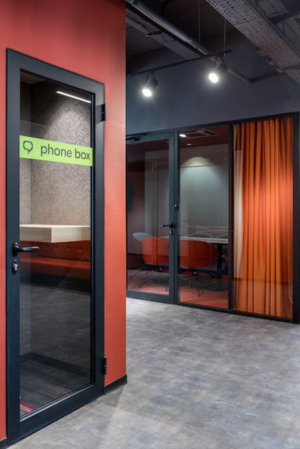 Empty hallway with phone box and conference room with glass doors and chairs in modern business center with creative design